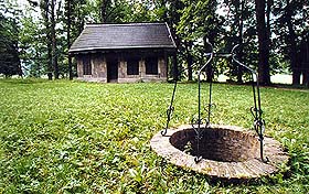 Schloss Červený Dvůr, Park, Häuschen aus Baumrinde, im Vordergrund ein Brunnen Schloss Červený Dvůr, Park, Häuschen aus Baumrinde, im Vordergrund ein Brunnen