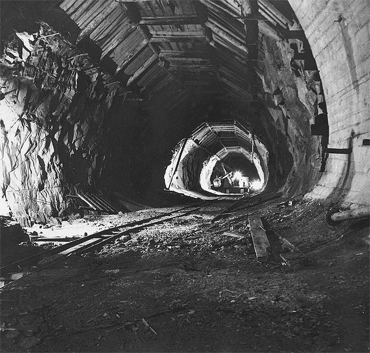 Hydro plant Lipno, waste tunnel, transport of digger D 500 into underground engine room, at ceiling of tunnel hangs timbering, February 1959, historical photo